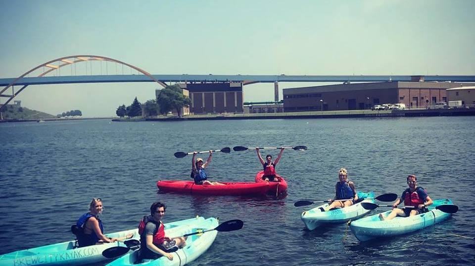 BCKTA A group of kayakers in single kayaks smiling on Lake Michigan