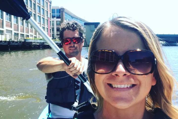 A couple smiling on a double kayak