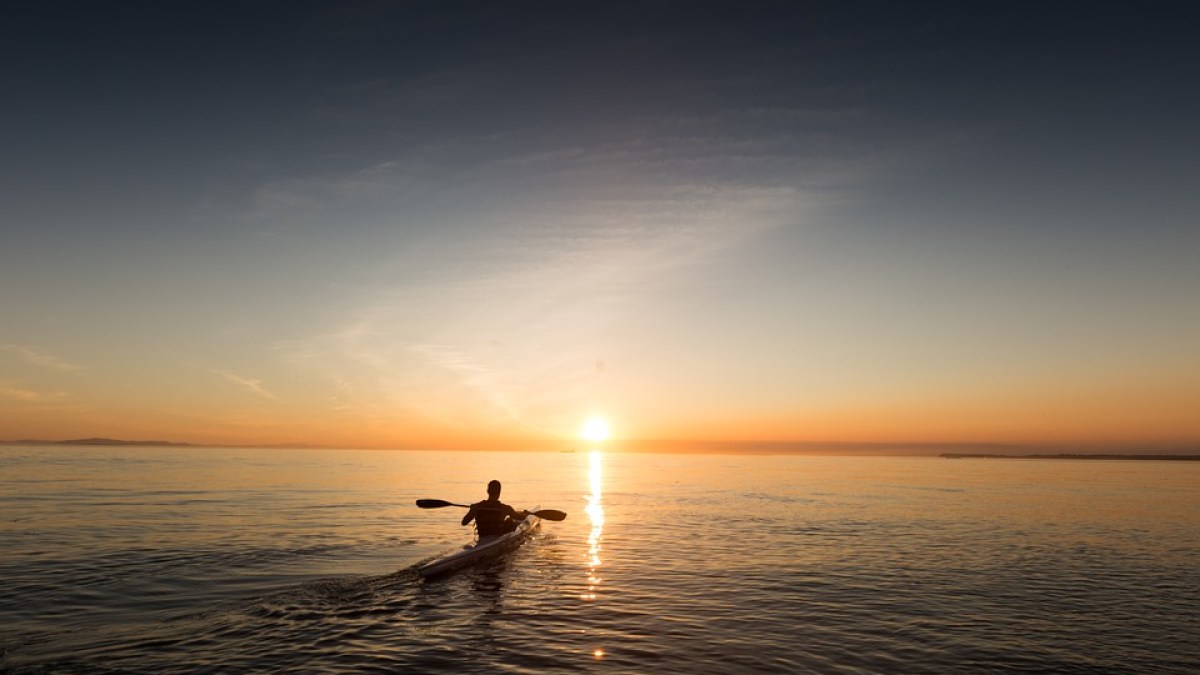 A kayaker peering into the sunset on Lake Michigan